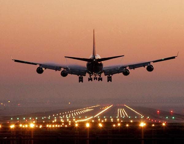 A plane landing at sunset