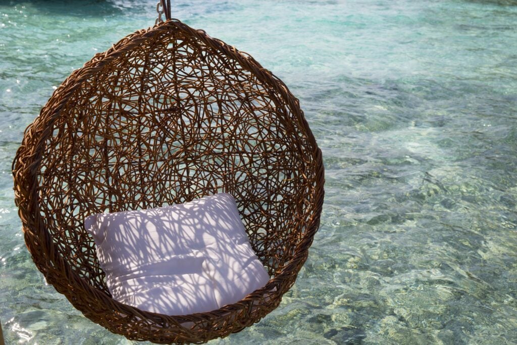 An egg chair over hanging the ocean 