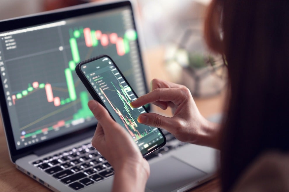 Closeup - Woman is checking Bitcoin price chart on digital exchange on smartphone, cryptocurrency future price action prediction.