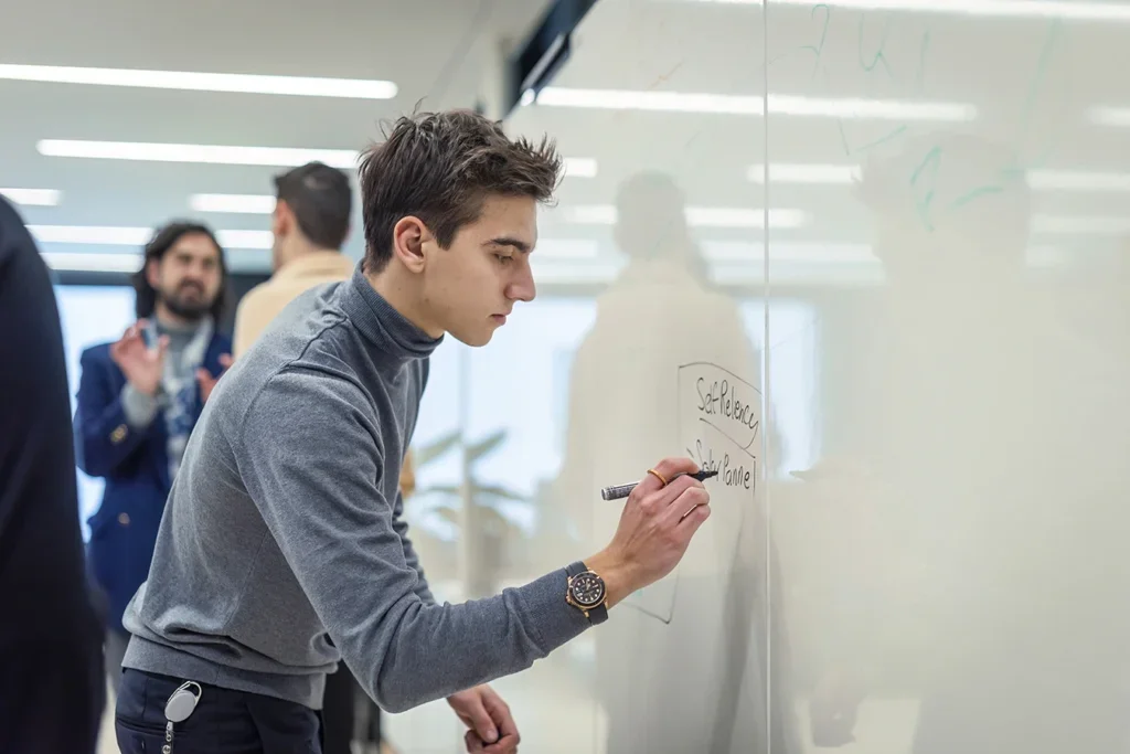 Student writing on a whiteboard at Institut auf dem Rosenberg