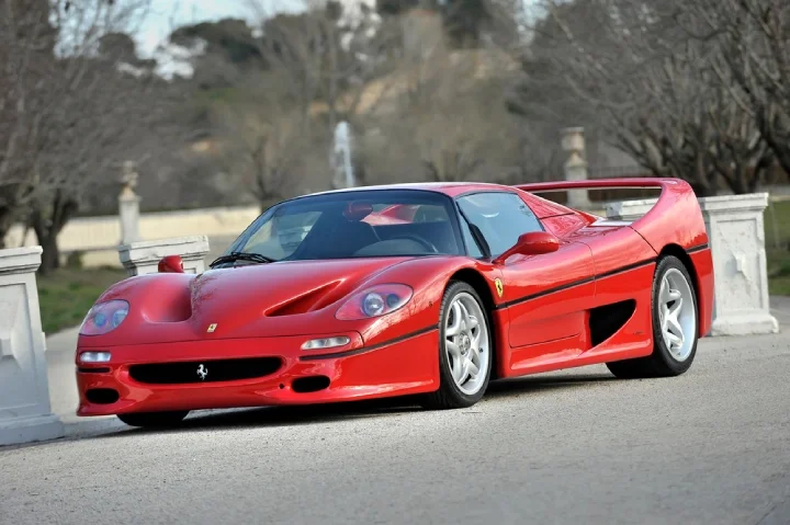 Red Ferrari F50 speeding on the road on a sunny day