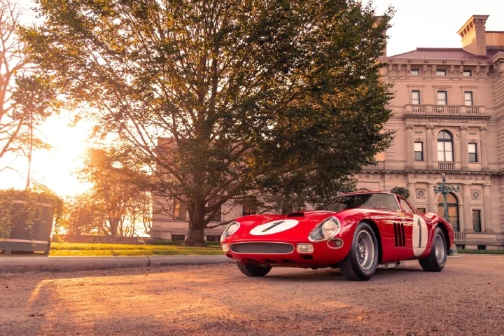 Red Ferrari 250 GTO at sunset, with a mansion and a tree in the background