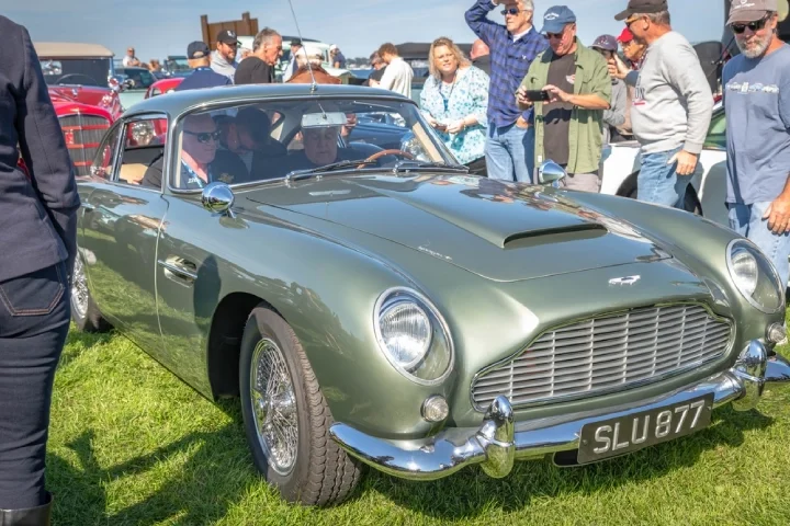 Jay Leno at a car meet on board of his green Aston Martin DB4