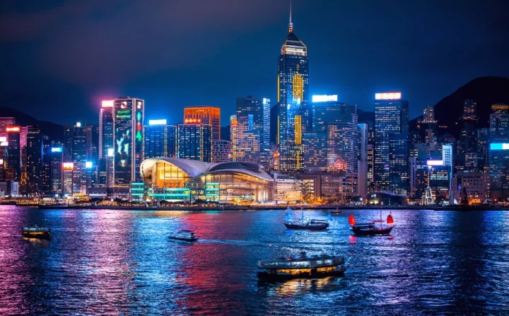 Hong Kong at night, with a view on the water with boats roaming around