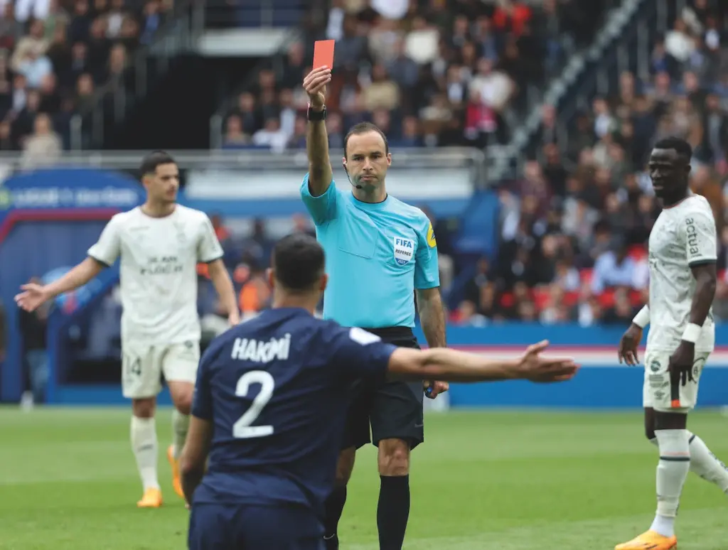 Referee holding up a red card to Morocco's Achraf Hakimi