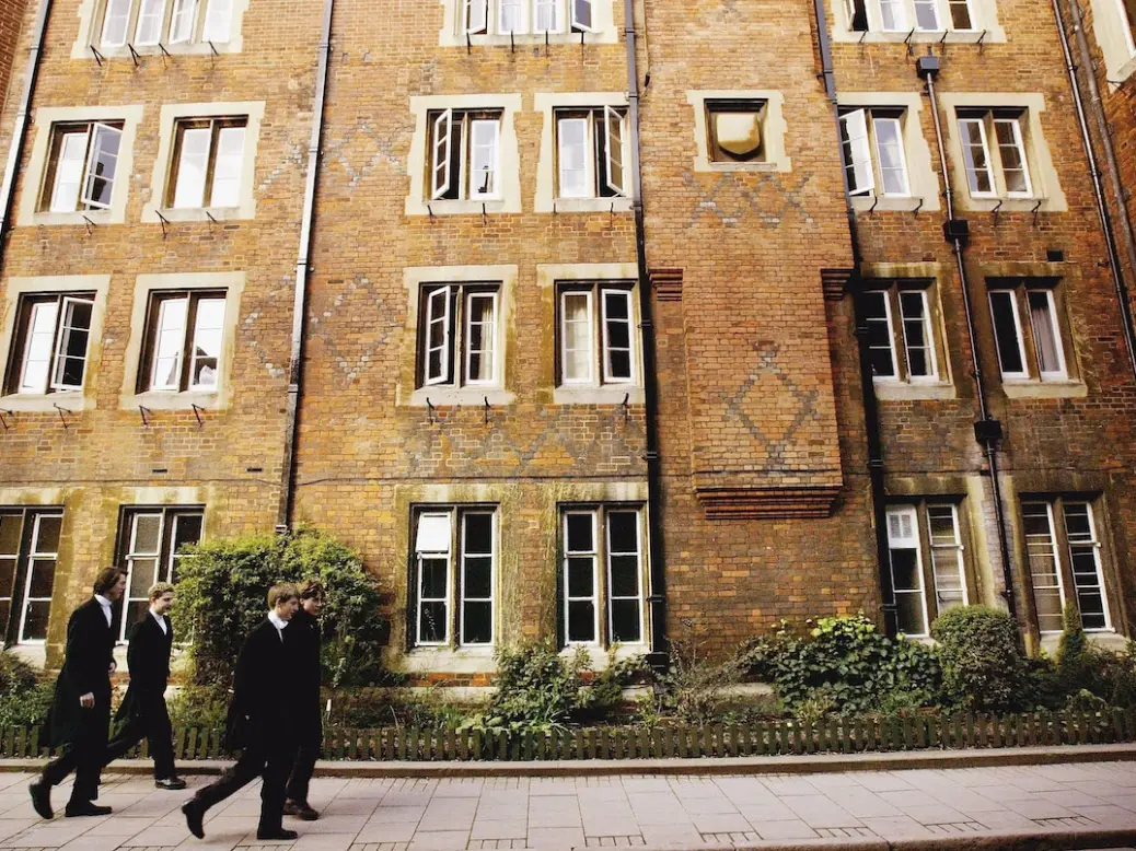 Pupils at Eton College hurry between lessons wearing the school uniform of tailcoats and starched collars