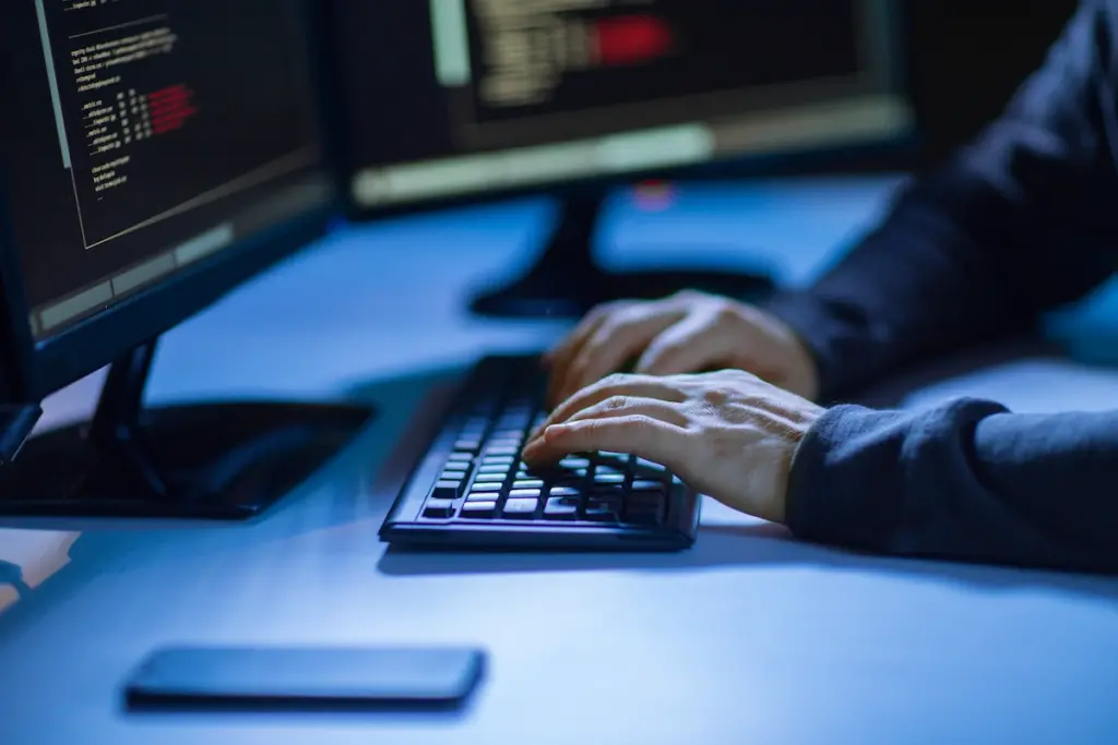 Hand of man typing on computer