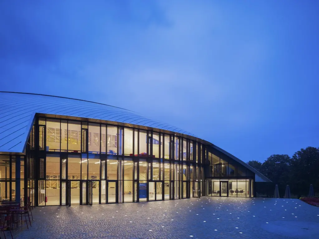 Main entrance to dome structure at dusk. Auditorium Carnal Hall at Le Rosey, Rolle, Switzerland. Architect: Bernard Tschumi, 2015. (Photo by: Christian Richters/View Pictures/Universal Images Group via Getty Images)