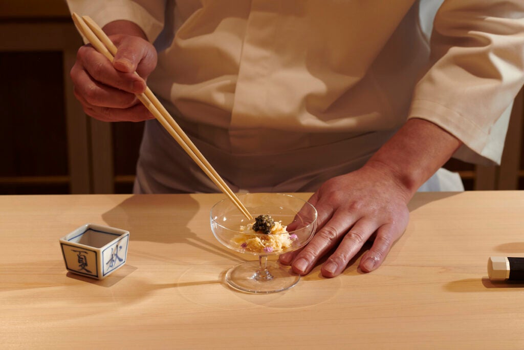 A sushi chef mixing flavours