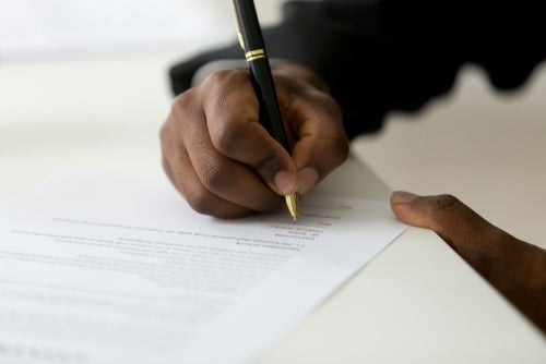 Professional man signs document in office