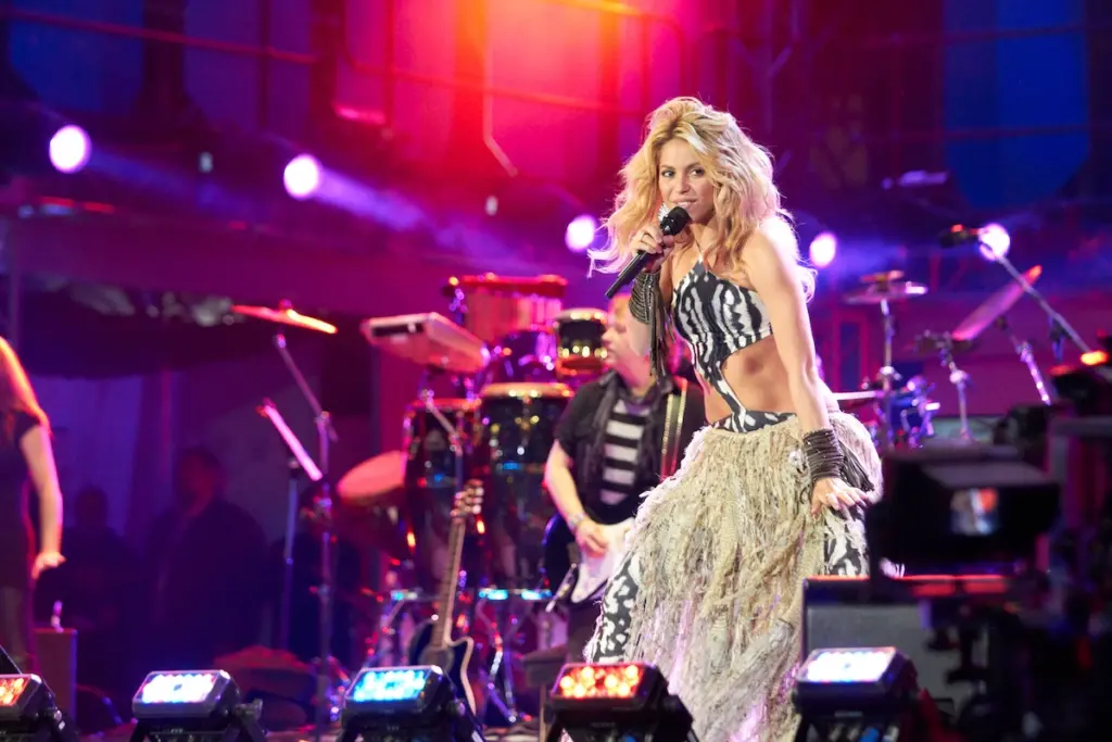 Shakira performing on stage wearing a crop zebra print top