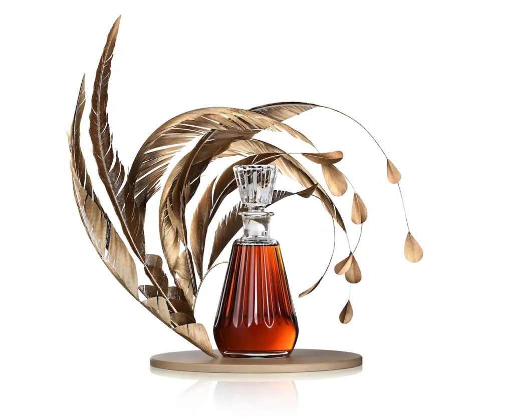 A bottle of Camus Les Ateliers Cognac with a plume of feathers 