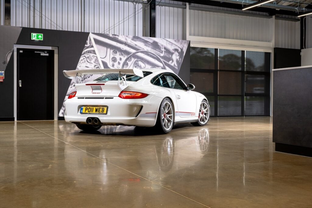 A white 2011 Porsche 997.2 GT3 RS 4.0 with its spoiler facing the camera