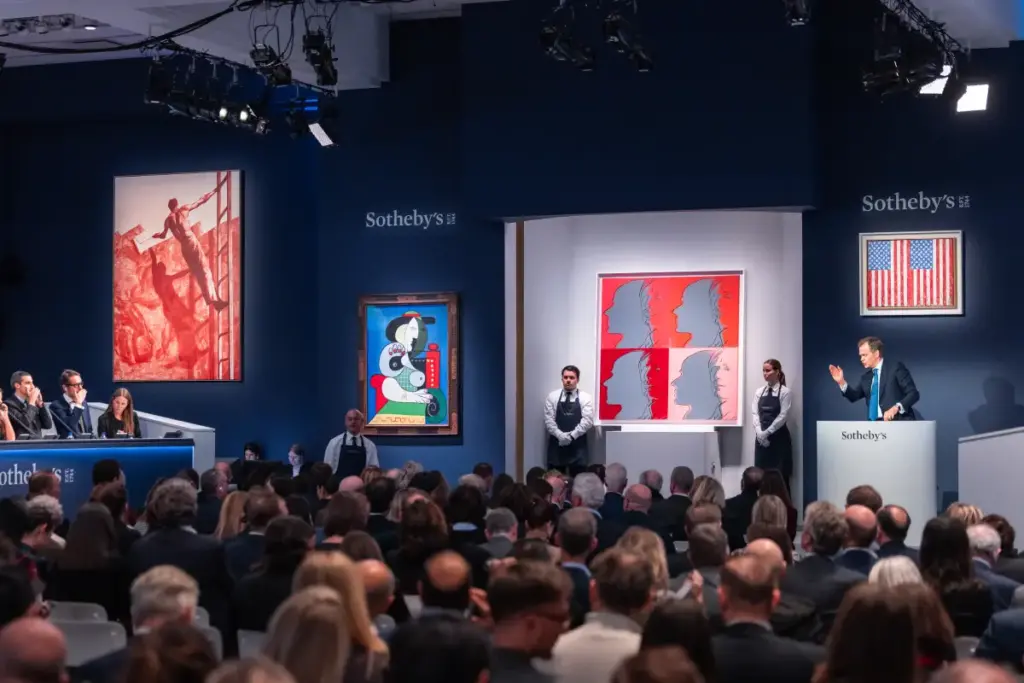 An auction at Sotheby's showing Sotheby's Chairman Auctioneer OliverBarker fielding bids during the Emily Fisher Landau Collection auction