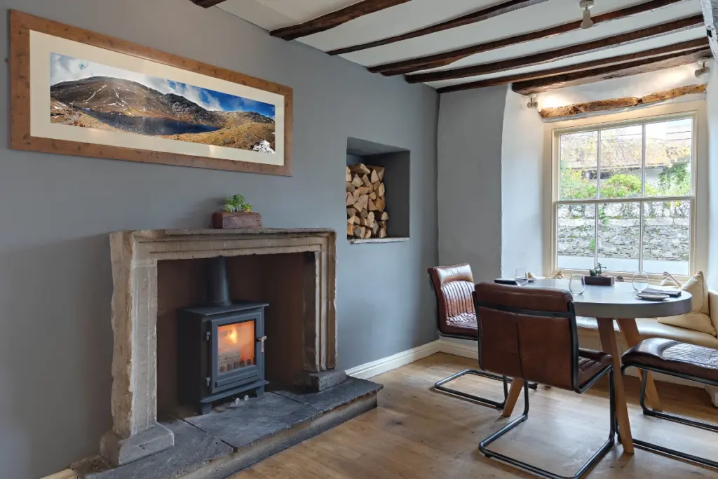 A woodburner and a table set for lunch with brown leather retro style chairs