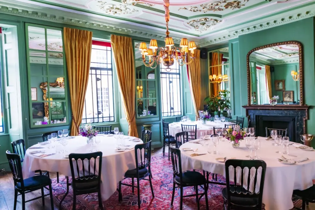 L'Escargot's green salon set with three round tables