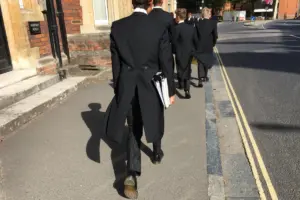 Etonian schoolboys, from the English independent boarding school, Eton College, dressed in traditional uniform of tails, going to class in the famous, historic town of Eton in Windsor, England