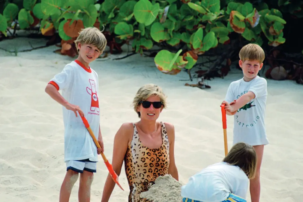 Princess Diana wearing a leopard print sundress and Prince Harry and a young friend holding spades on the beach
