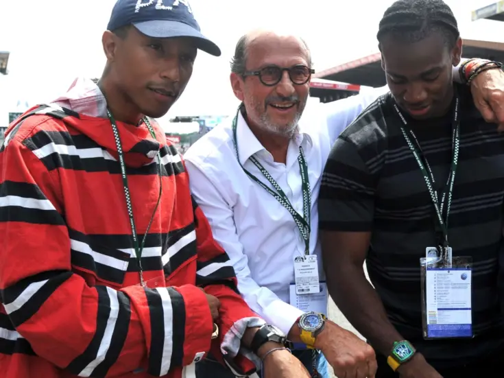 Founder Richard Mille (centre), musician Pharrell Williams (far left) and sprinter Yohan Blake pose with their watches at Le Mans in 2016