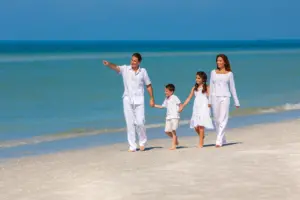 A family wearing white walking along a tropical beach