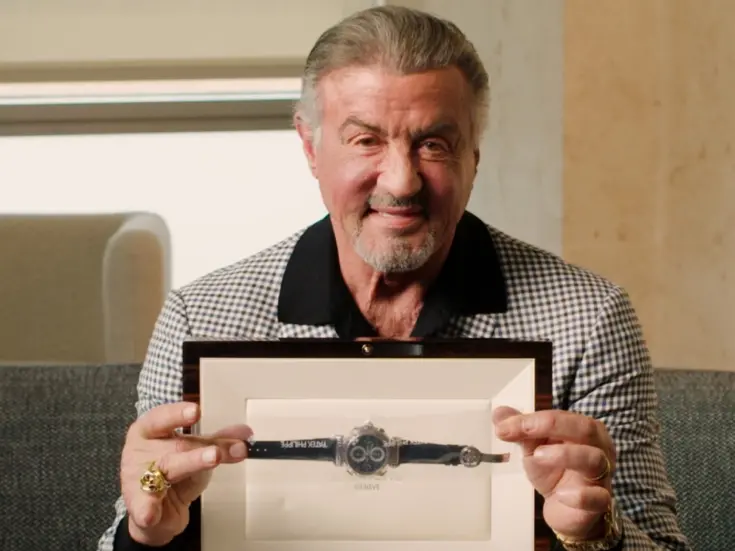 Sylvester Stallone holding a watch still in in presentation box.
