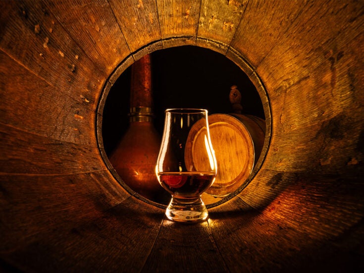 A glass of Scotch whisky in a barrel