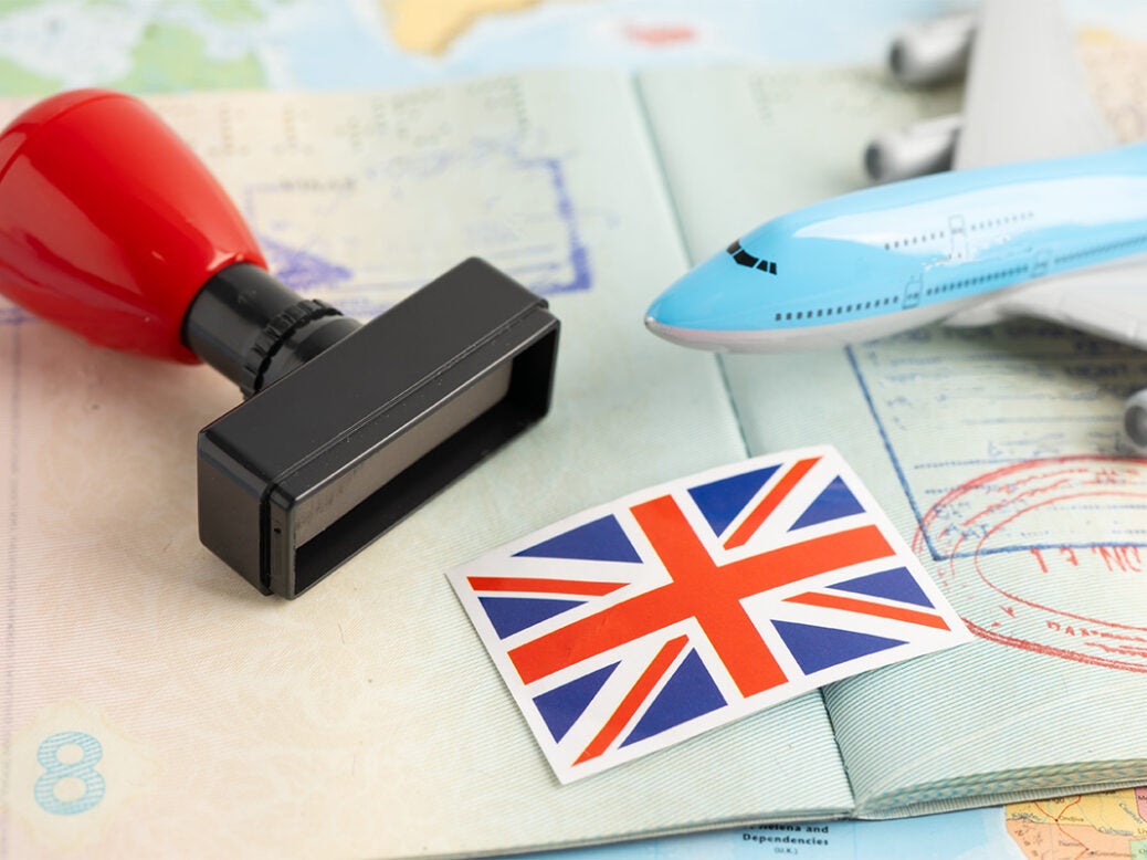 Stock image showing a British flag, passport, stamp and model plane non-doms