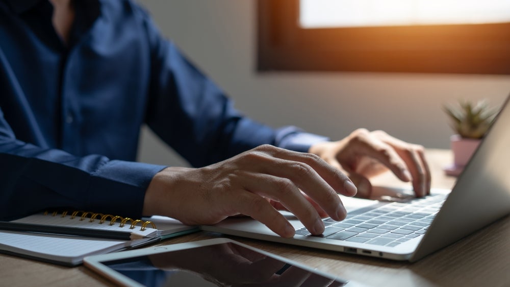 man typing on Laptop