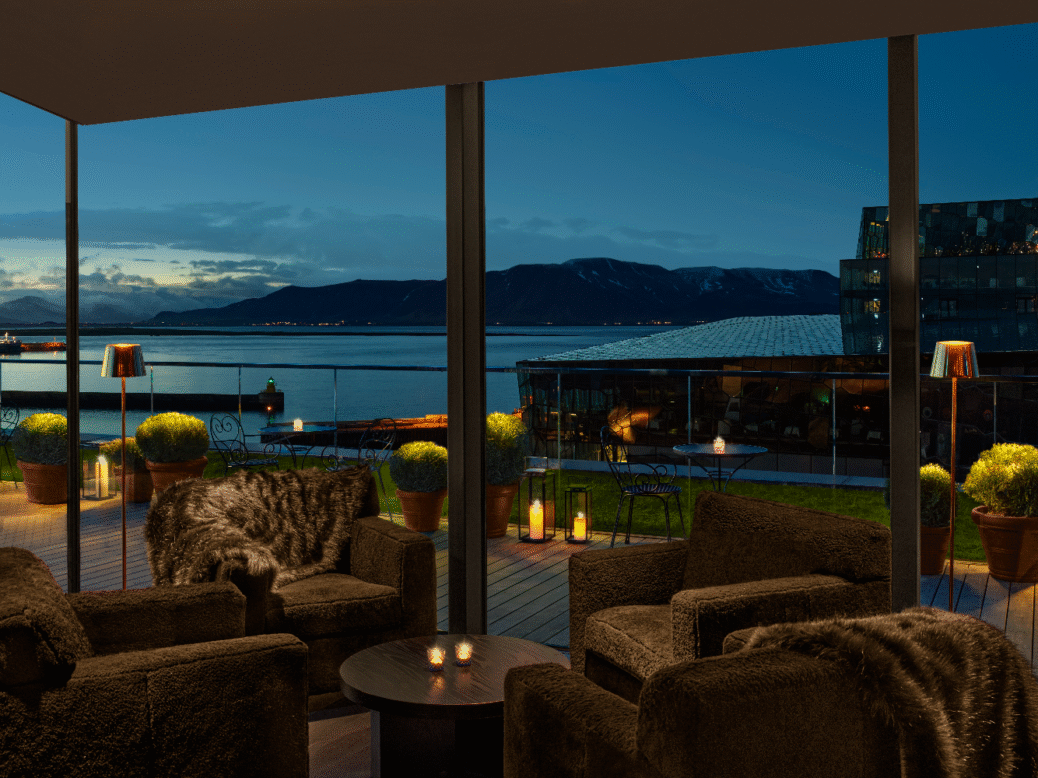 Harbour views stretch across fishing boats and passing cruise ships from the hotel’s waterfront setting